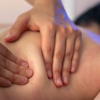 Therapist massages clients back in closeup view. Calm atmosphere and natural light turn wellness into a stylish daily moment. Energy in simple things.