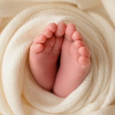 Small beautiful legs of a newborn baby in the first days of life. Baby feet of a newborn